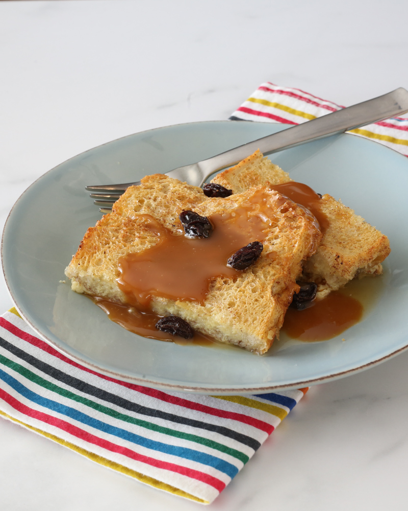 old-fashioned bread pudding on a plate with caramel sauce