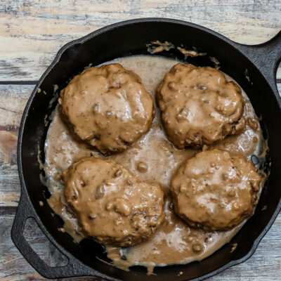 Overhead photo of hamburger steaks with gravy.