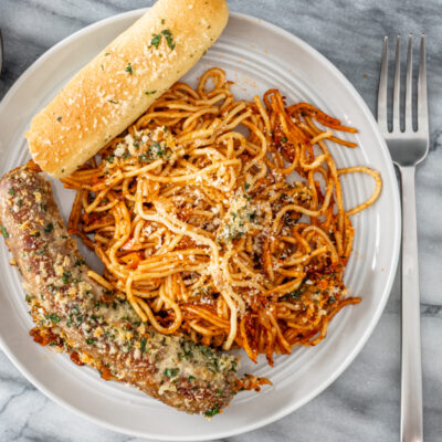 Savory spaghetti topped with fresh basil and grated cheese.