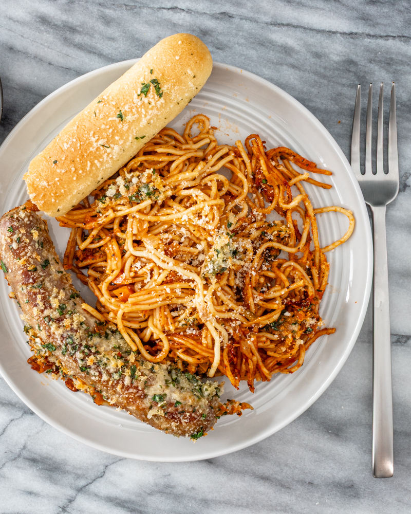 Savory spaghetti topped with fresh basil and grated cheese.