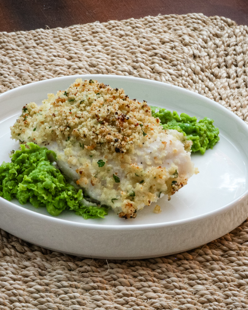 pea puree on a plate with a halibut filet
