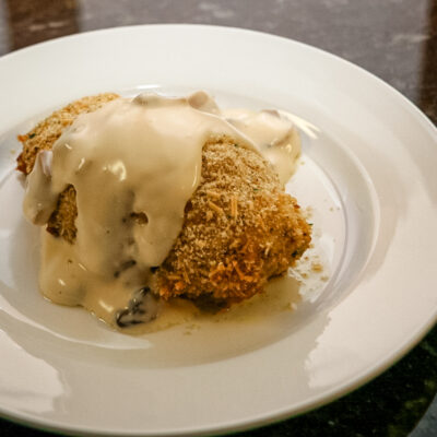 pesto chicken rolls on a plate with mornay sauce