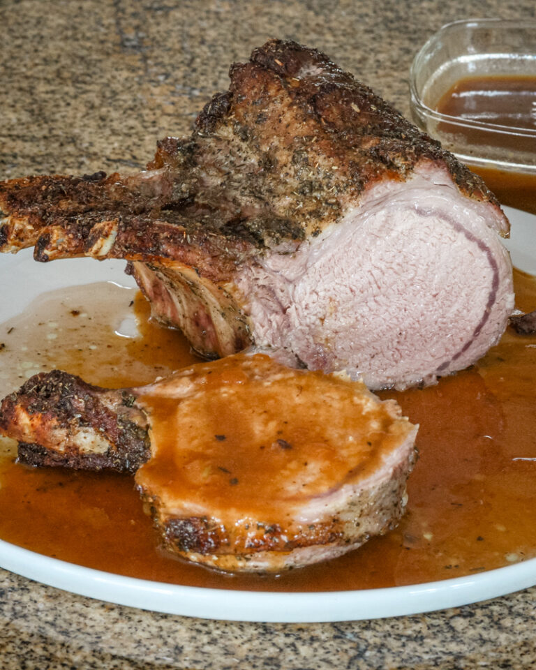 pork rack with madeira pan sauce on a serving plate.