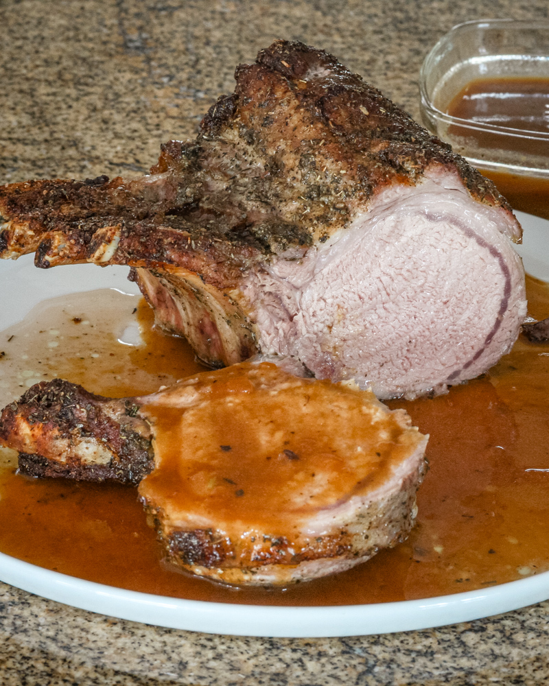 pork rack with madeira pan sauce on a serving plate.