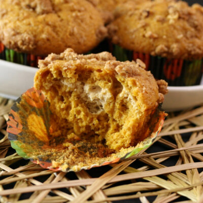 A dish with pumpkin cream cheese muffins and one cut in half