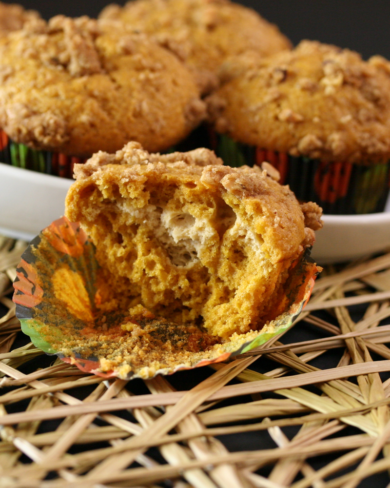 A dish with pumpkin cream cheese muffins and one cut in half