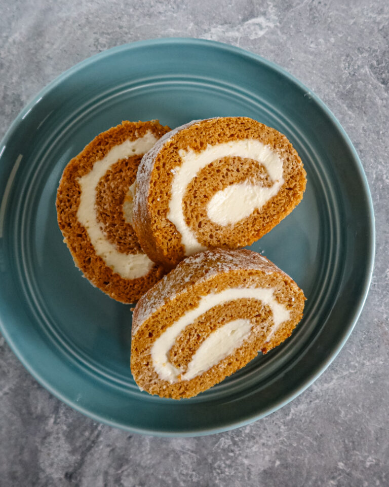 Slices of pumpkin cake roll with cream cheese filling.