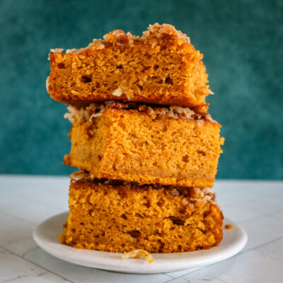 Pumpkin cake with broiled coconut pecan topping, stacked on a plate