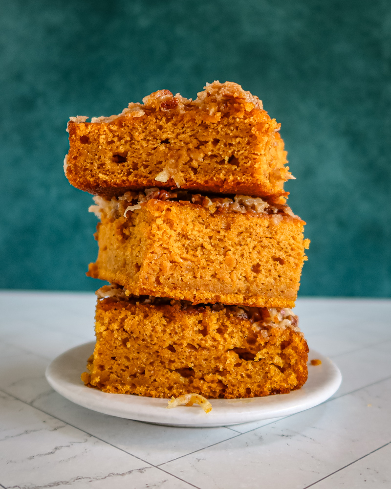 Pumpkin cake with broiled coconut pecan topping, stacked on a plate