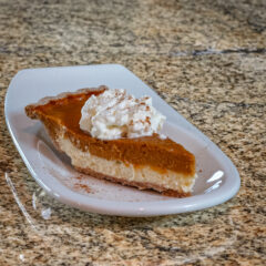 pumpkin pie with cream cheese layer on a dessert plate