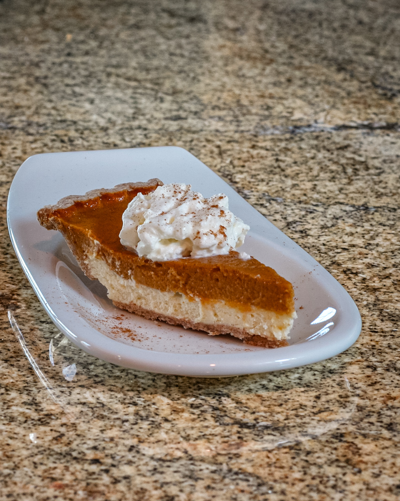 pumpkin pie with cream cheese layer on a dessert plate