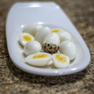 Hard boiled quail eggs in a small white dish.