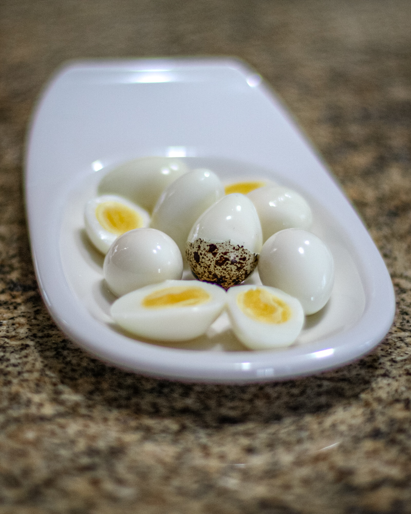 Hard boiled quail eggs in a small white dish.