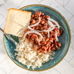 Black-eyed peas with rice and cornbread in a blue bowl with fork.