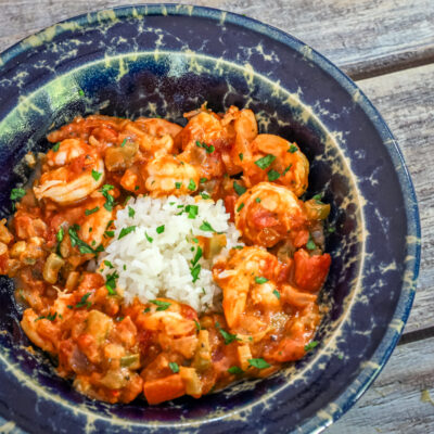 Shrimp Creole with rice in a pottery bowl.
