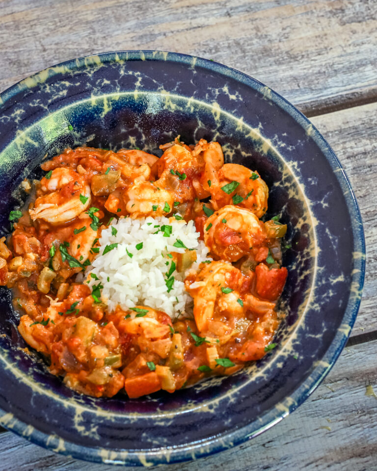 Shrimp Creole with rice in a pottery bowl.