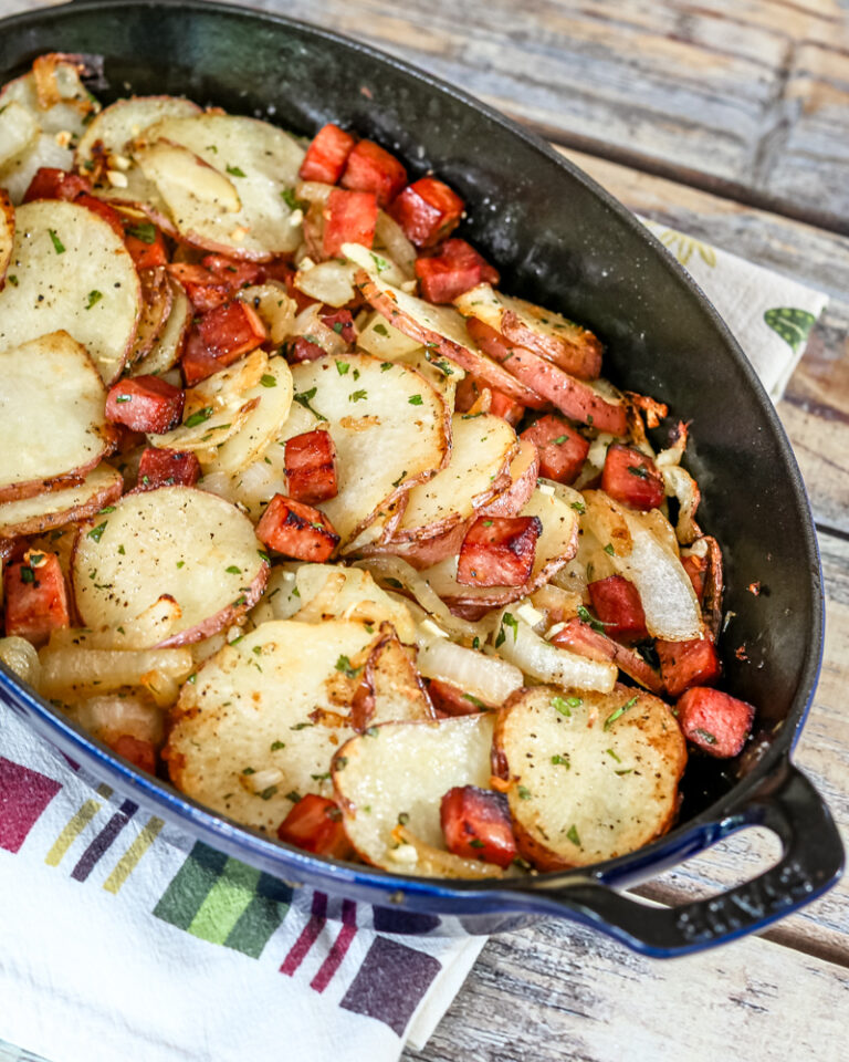Roasted potatoes and ham in a baking dish.
