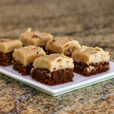 Fudge brownie bars topped with creamy white chocolate and nuts on a small