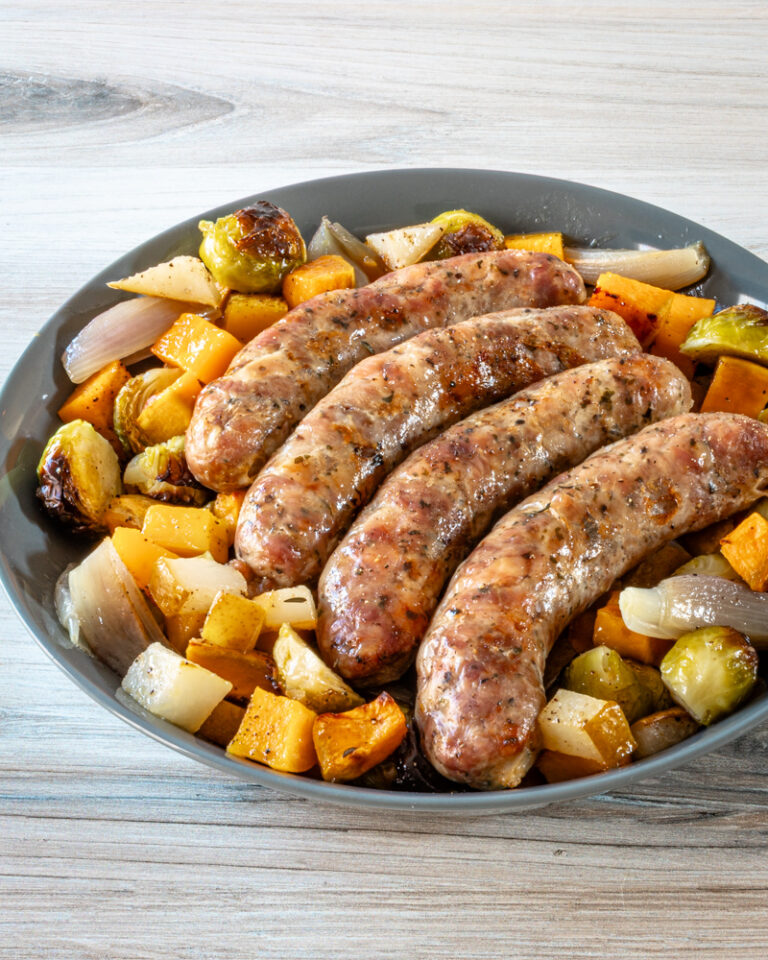 Sheet pan sausages surrounded by vegetables.