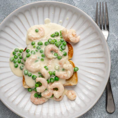 Shrimp wiggle with creamy sauce and peas over toast.