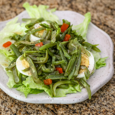 a simple green bean salad on a lettuce-lined plate