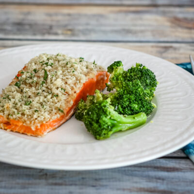 broccoli with lemon shown with a salmon fillet on a plate