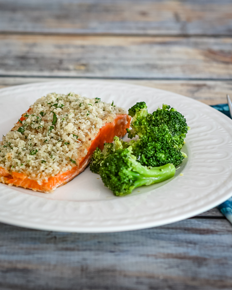 broccoli with lemon shown with a salmon fillet on a plate
