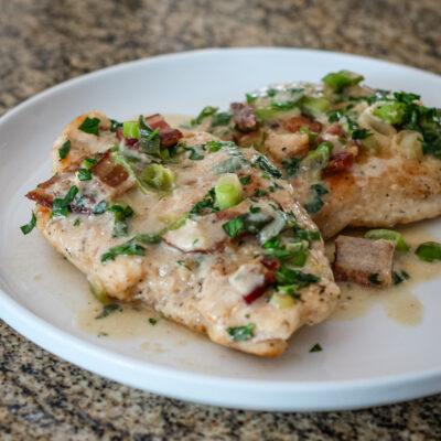 chicken with bacon and sour cream sauce on a serving plate