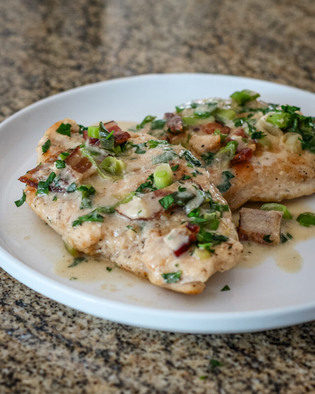 chicken with bacon and sour cream sauce on a serving plate