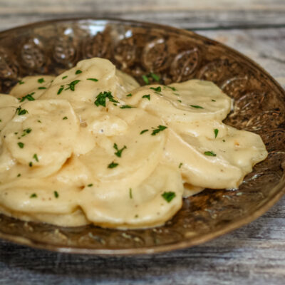 crock pot scalloped potatoes with cheese on a brown plate