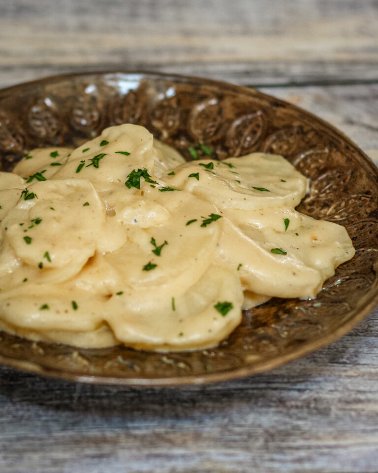 crock pot scalloped potatoes with cheese on a brown plate