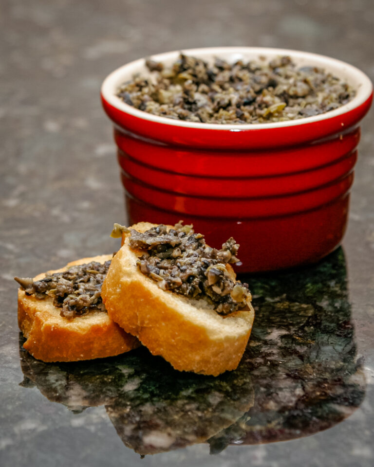 Olive tapenade spread on small crostini.