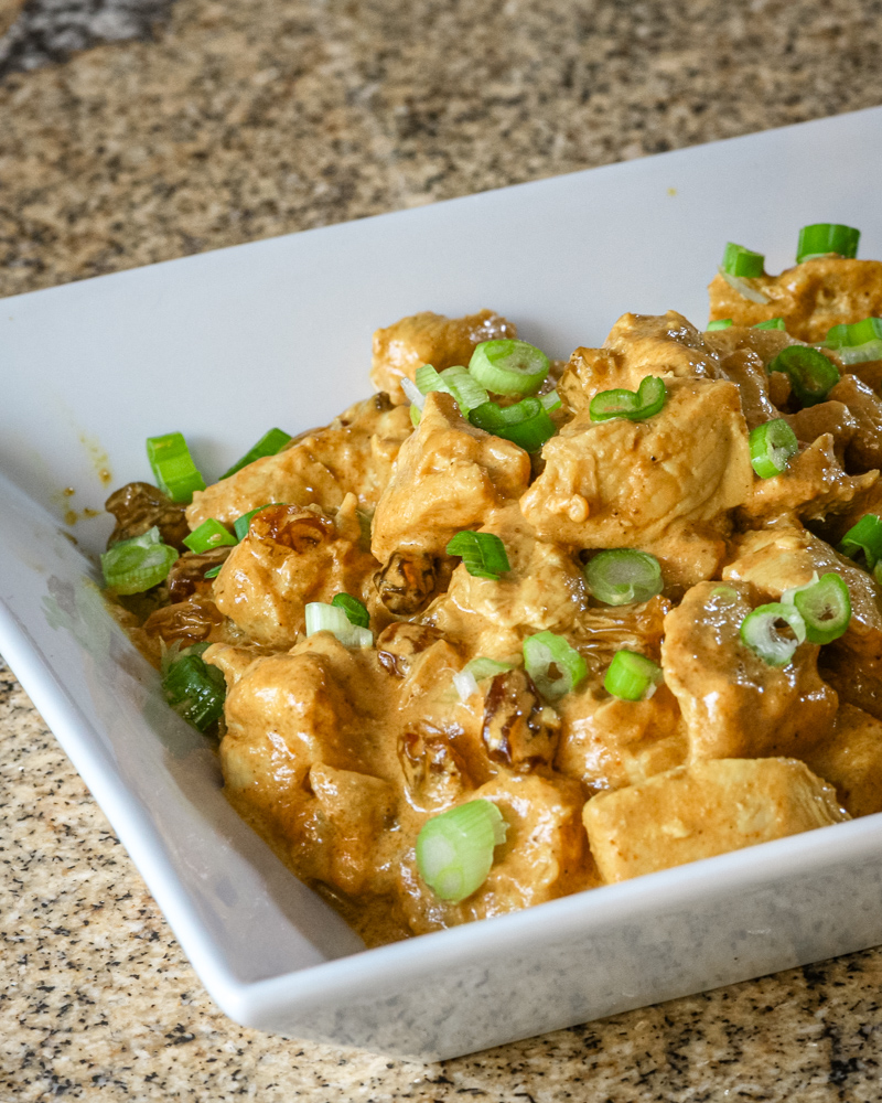 Creamy turkey curry with green onion garnish.