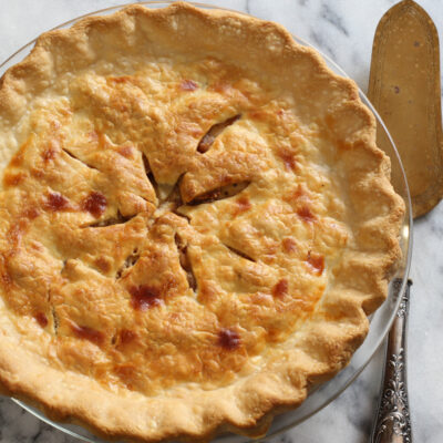 Apple pie with a pie server next to it.