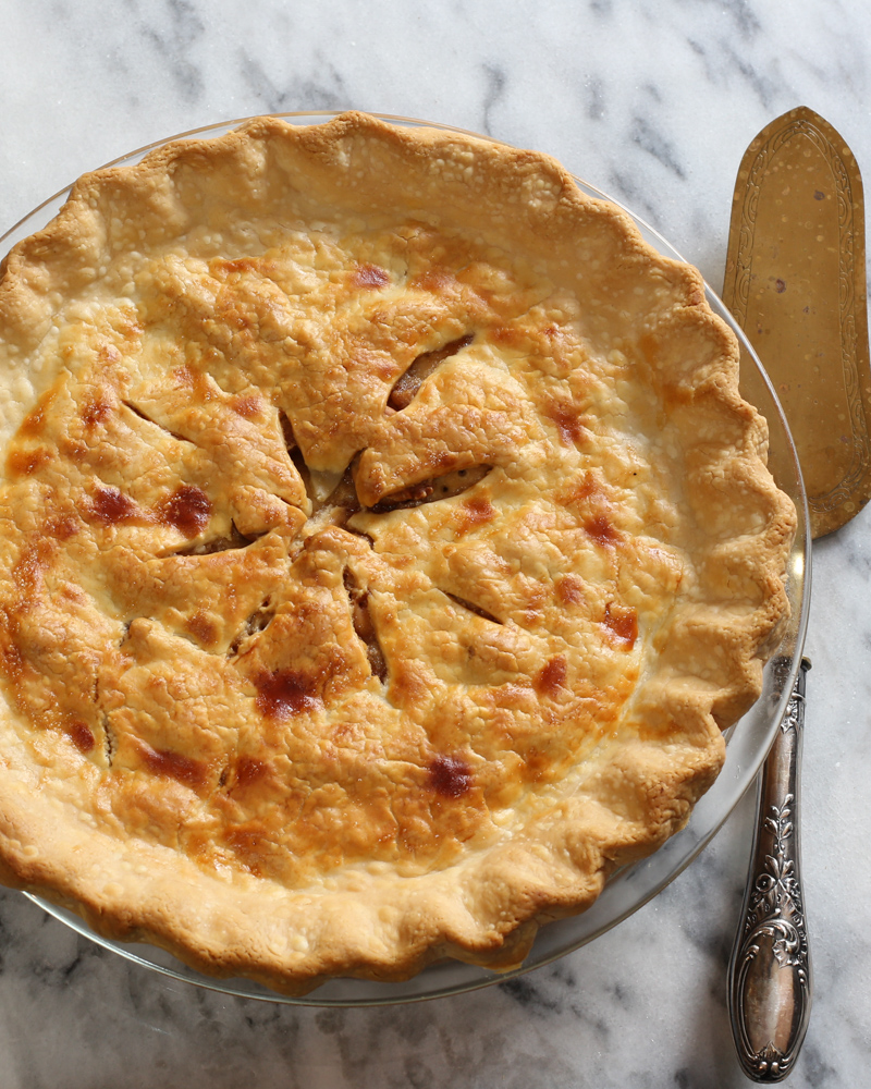 Apple pie with a pie server next to it.
