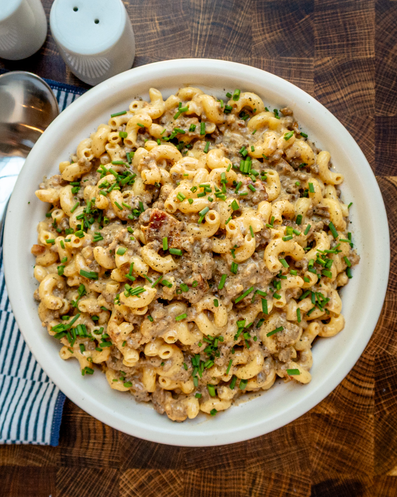 Creamy ground beef and macaroni casserole garnished with chopped chives.