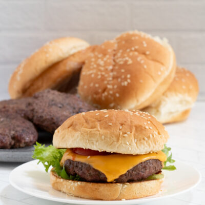 A bacon cheeseburger on a sesame seed bun.