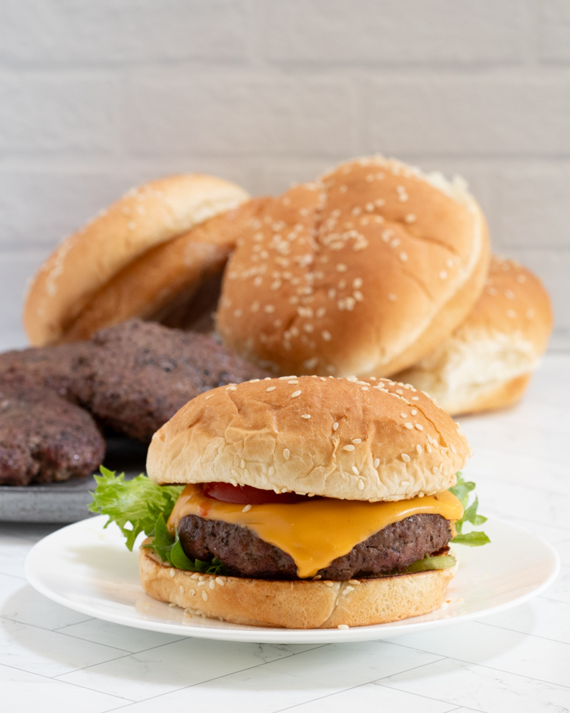 A bacon cheeseburger on a sesame seed bun.