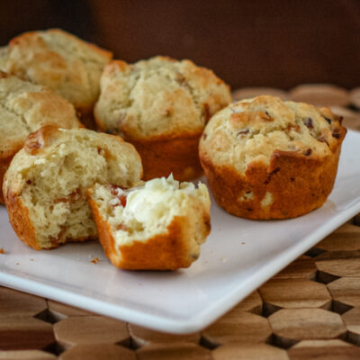 bacon muffins on a square plate, one is buttered