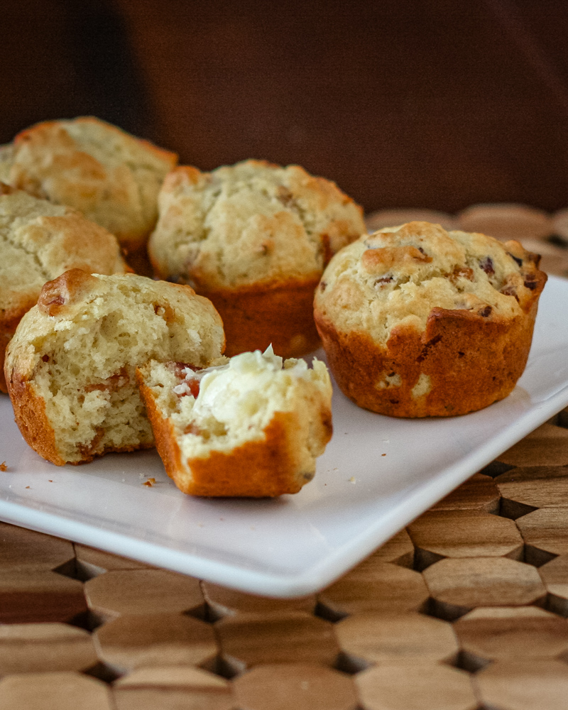 bacon muffins on a square plate, one is buttered