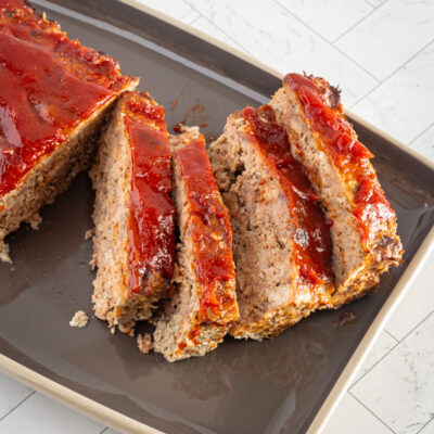 meatloaf with glaze, sliced, on a serving tray.