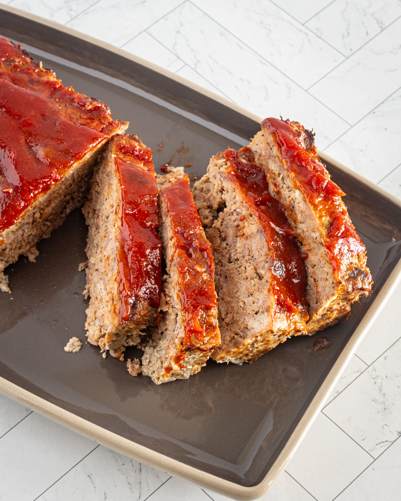 meatloaf with glaze, sliced, on a serving tray.