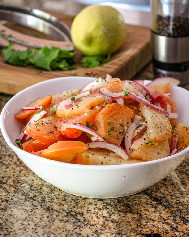 Beet salad with vinaigrette and red onions, in a serving bowl.