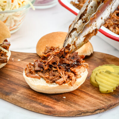 Slow cooker pulled pork shown on a small bun.