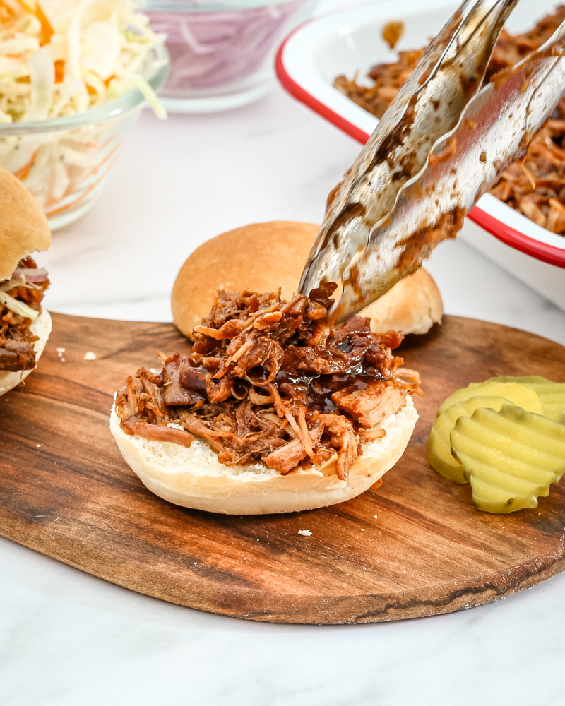 Slow cooker pulled pork shown on a small bun.
