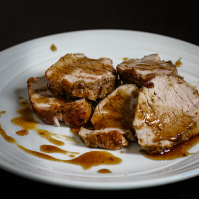 Pork tenderloin on a plate with bourbon and cola glaze.