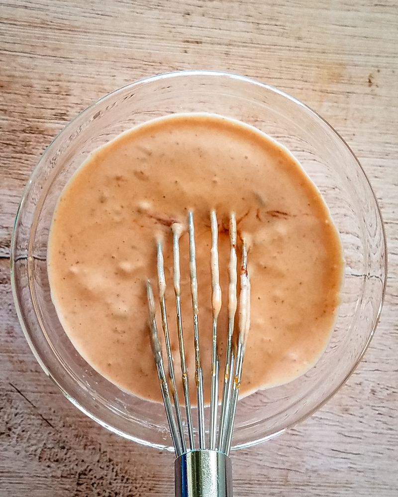 Mixing buffalo mayonnaise spread (or sauce or dip), with a whisk.