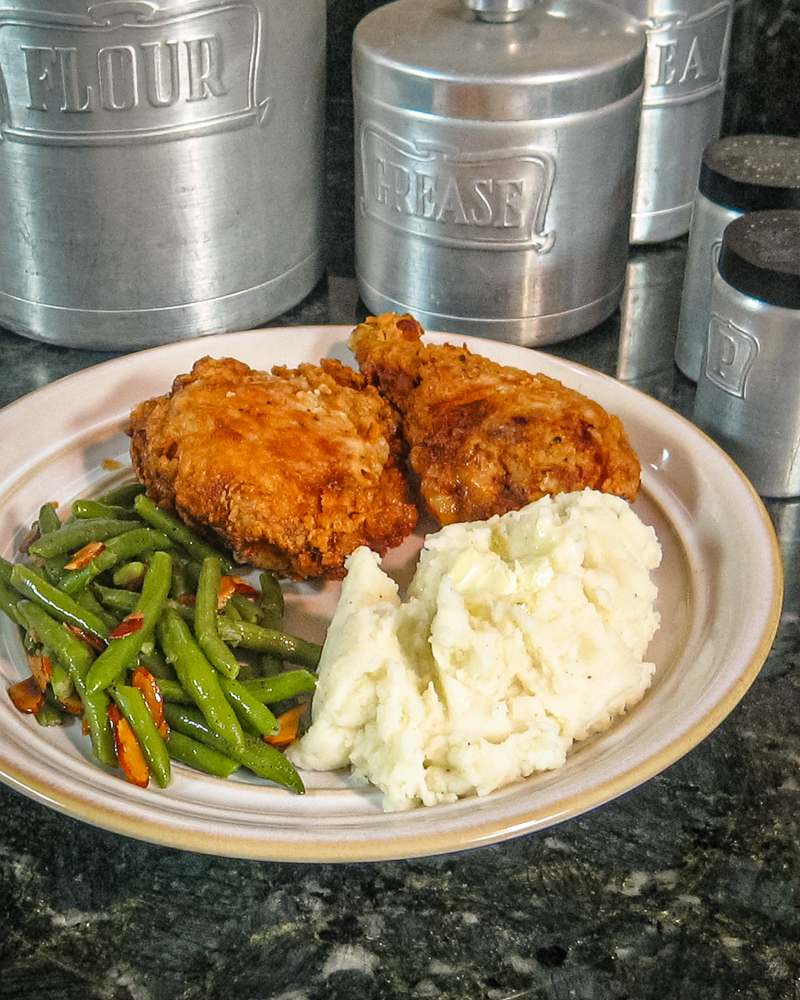 Plate with buttermilk fried chicken, mashed potatoes, and green beans