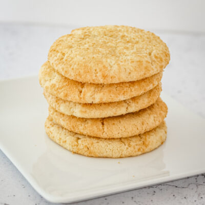 Sugar cookies stacked on a white plate.