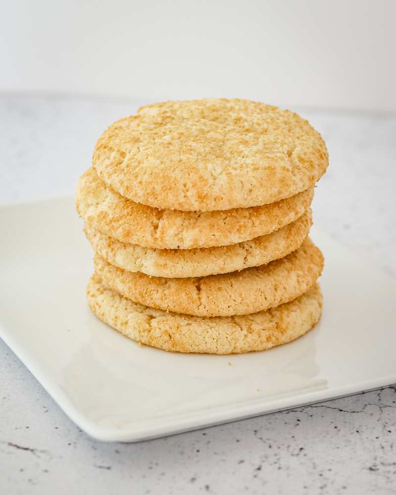 Sugar cookies stacked on a white plate.